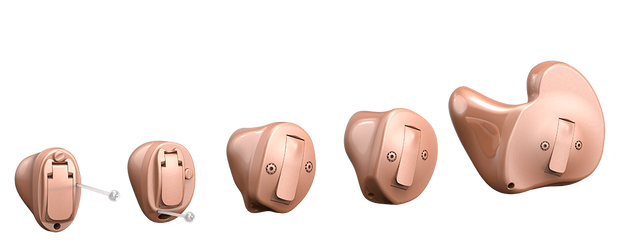 Five different shapes and sizes of skin-toned customized hearing aids align in ascending order from smallest to largest.