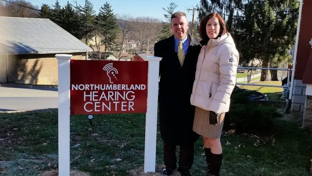 Ethan and Deanna Ikeler, owners of Northumberland Hearing Center, standing outside the office location.